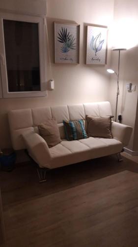a white couch in a living room with a flat screen tv at Apartamentos Marques De La Merced in Málaga