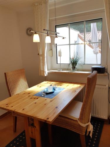 een houten tafel met 2 stoelen en een raam bij Haus Inge Ysker in Greetsiel