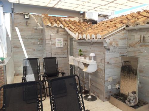 a barber shop with chairs and a table and a fireplace at Apartamentos Marques De La Merced in Málaga