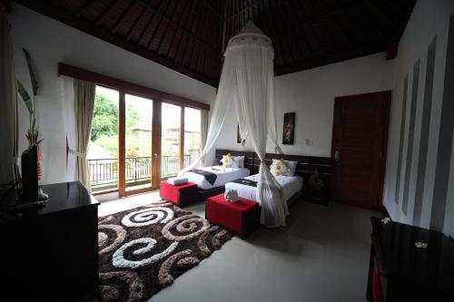 a living room with a bed and a couch at Baruna Sari Villa in Ubud