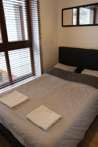 two towels on a bed in a room with a window at Apart Prestige Ząbkowska Old Town in Warsaw