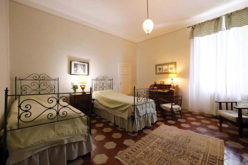 Un dormitorio con dos camas y una mesa y una ventana. en Villa La Strega, en Siena