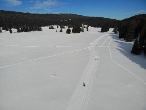 a group of people skiing down a snow covered slope at Grand Hôtel des Rasses & Wellness in Les Rasses