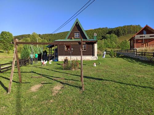 a group of people standing in a field in front of a house at Romantika in Šavnik