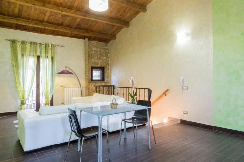 ピアッツァ・アルメリーナにあるIl Giardino del Saraceno Houseのリビングルーム(白いソファ、テーブル付)