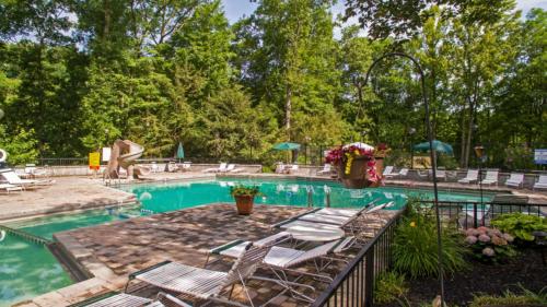a pool with chaise lounge chairs and a swimming pool at Smoky Bear Hideaway in Gatlinburg