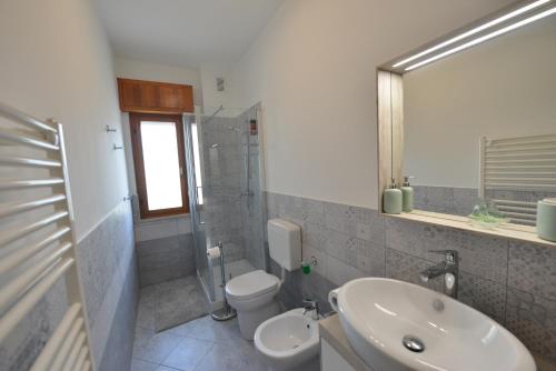La salle de bains est pourvue d'un lavabo, de toilettes et d'un miroir. dans l'établissement Galleria Excelsior, à Grado