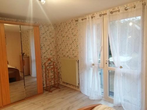 a room with a sliding glass door and a window at Chez Papinette, proche gare et centre, pdj compris in Niort