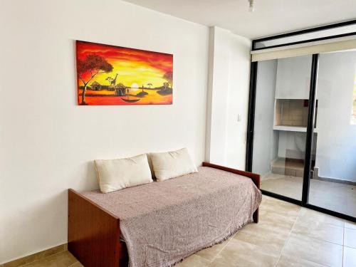 une chambre avec un lit et un tableau au mur dans l'établissement Edificio Tempo, à Villa Carlos Paz