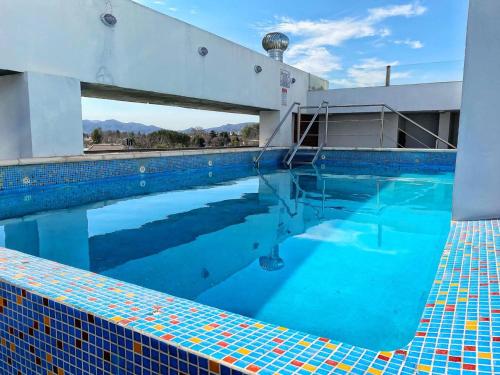 une grande piscine à l'eau bleue dans l'établissement Edificio Tempo, à Villa Carlos Paz