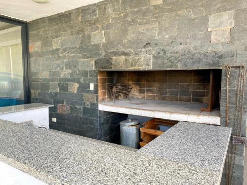 Cette chambre est dotée d'un mur en briques et d'une cheminée. dans l'établissement Edificio Tempo, à Villa Carlos Paz