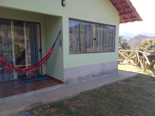 a room with a hammock on the side of a house at Lumiar Chalé Jardim do Sossego in Lumiar