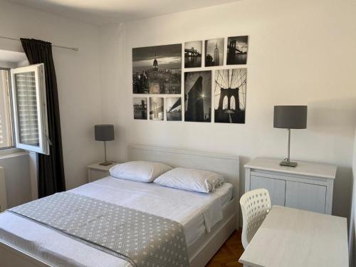 a bedroom with a bed and a table and pictures on the wall at Apartments Barbaresko in Lumbarda