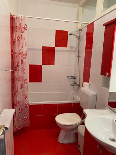 a red and white bathroom with a toilet and a sink at Apartments Barbaresko in Lumbarda