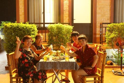 a group of people sitting around a table at Mai Chau Xanh Bungalow in Mai Châu