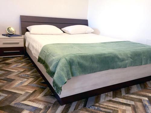 a bedroom with a large bed with a green blanket at Greta's place - Elegant home with Exclusive location and Seaview in Izola
