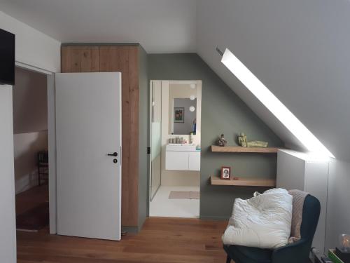 a living room with a staircase and a room with a couch at Het Meikenshof in Dentergem