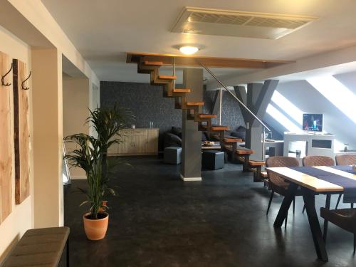 un restaurante con escalera, mesas y sillas en Ferienwohnung Zum Deutschen Hause, en Lübbenau