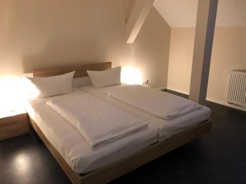 1 dormitorio con 1 cama con sábanas y almohadas blancas en Ferienwohnung Zum Deutschen Hause, en Lübbenau