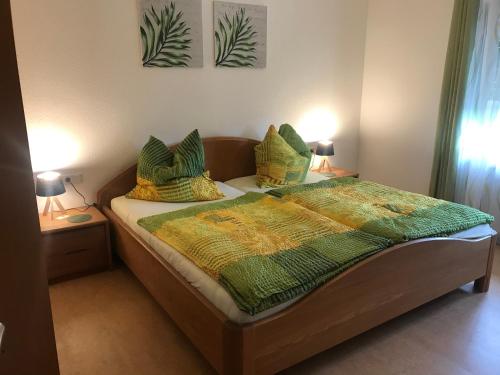 a bedroom with a bed with a green and yellow comforter at Zollern-Alb Aktiv in Albstadt
