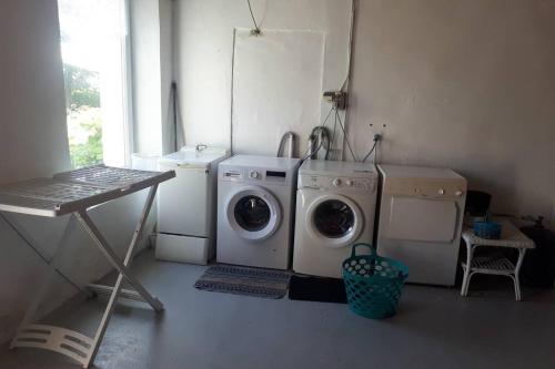 a laundry room with a washing machine and a washer at Ty Kreiz in Saint-Ségal