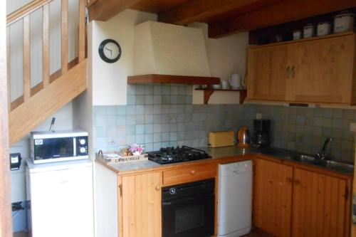 a kitchen with wooden cabinets and a stove top oven at Ty Kreiz in Saint-Ségal