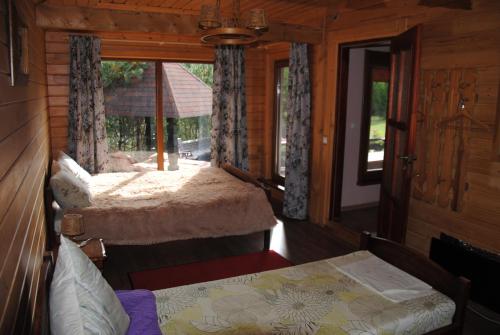 1 dormitorio con 2 camas y ventana en Sodyba Ciciriai, en Vėdariai
