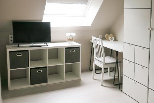 a room with a desk with a television and a chair at Les Gîtes de la pointe de Caux in Croix Bigot