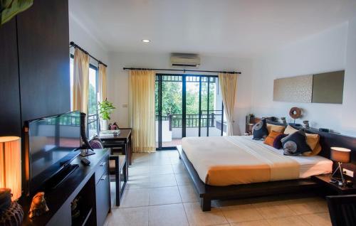 a bedroom with a bed and a desk and a television at Sang Serene House in Chiang Mai