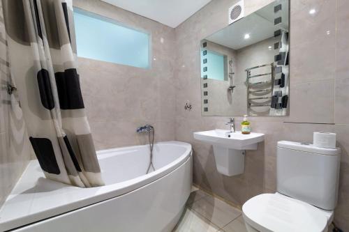 a bathroom with a tub and a toilet and a sink at City Center 2-bedroom apartment in Dnipro