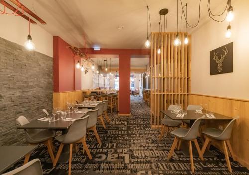 a restaurant with tables and chairs and a brick wall at Hotel le Sacca, nouvelle équipe in Cauterets