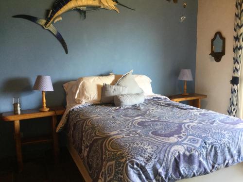 a bedroom with a bed with two nightstands and two lamps at Hawk's Nest Bed & Breakfast in La Laguna de San Carlos
