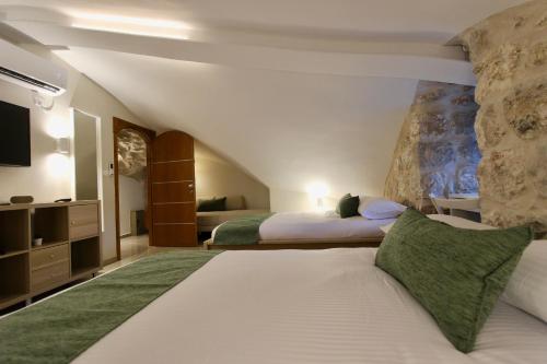 a hotel room with two beds and a tv at St. John Apartment in Jerusalem