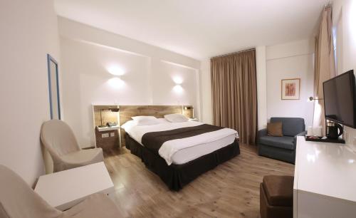 a hotel room with a bed and a tv at Centrum Hotel - City Center in Nicosia