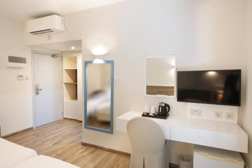 a living room with a white couch and a tv at Centrum Hotel - City Center in Nicosia