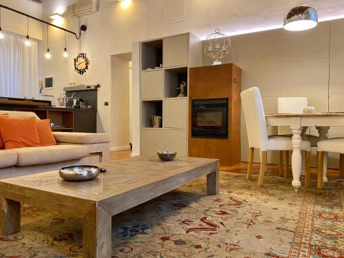 a living room with a couch and a table and a dining room at Kindness art apartment in historic center in Arona