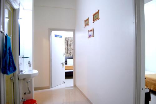 La salle de bains blanche est pourvue d'un lavabo et d'un miroir. dans l'établissement Teerth Villa, à Nashik