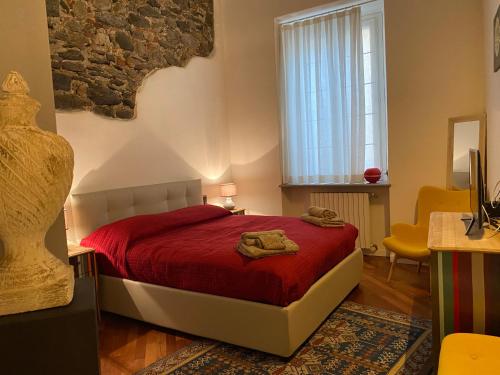 a bedroom with a red bed and a window at Kindness art apartment in historic center in Arona