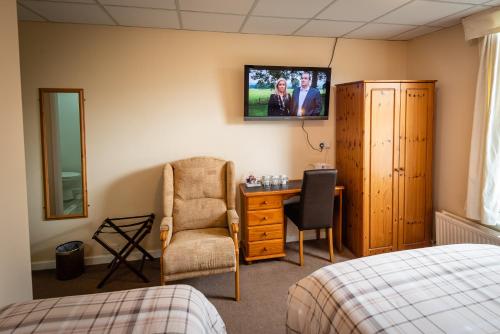 a bedroom with a bed and a chair and a desk at Aarondale Guest House in Hartlepool