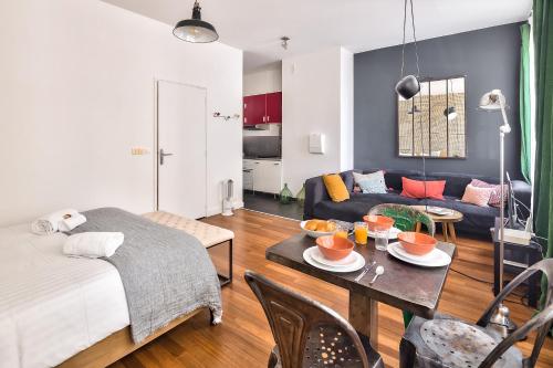 a living room with a bed and a table with food on it at Studio of Liberty in Paris