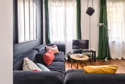 a living room with a blue couch with pillows at Studio of Liberty in Paris