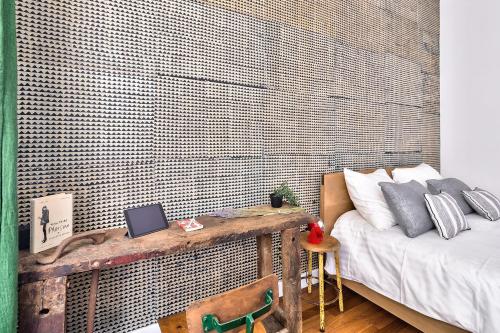 a bedroom with a bed and a table with a laptop at Studio of Liberty in Paris