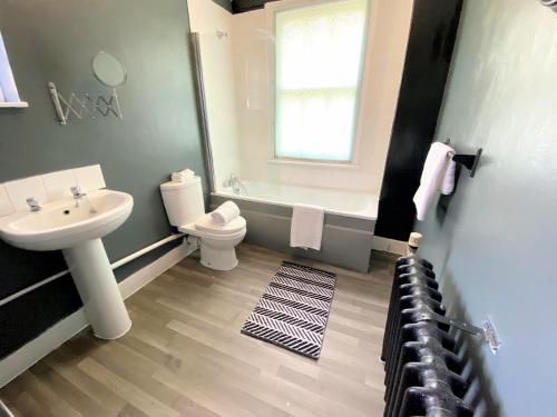 a bathroom with a sink and a toilet and a tub at Spacious Canterbury City Centre Gem House with Parking in Canterbury