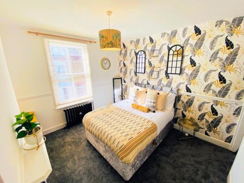 a bedroom with a bed and a wall with a mural at Spacious Canterbury City Centre Gem House with Parking in Canterbury