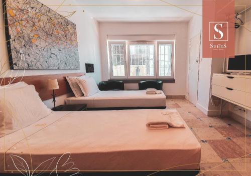 Habitación de hotel con 2 camas y TV en Yellow Suites, en Cascais