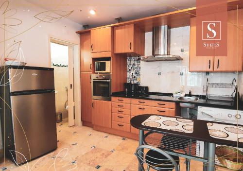 a kitchen with a refrigerator and a table in it at Yellow Suites in Cascais