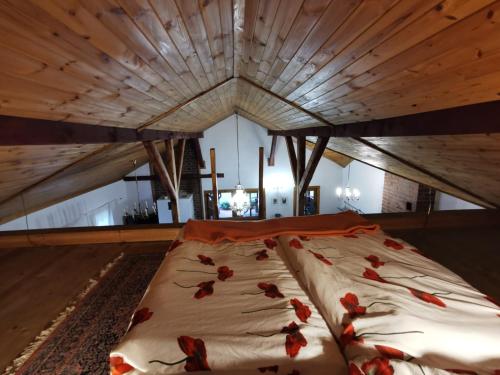 a large bed with red flowers on it in a room at Agroturystyka Sielanka nad Stawem in Turawa