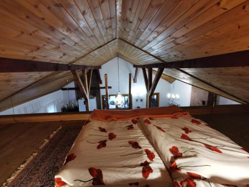 duże łóżko z czerwonymi kwiatami w pokoju w obiekcie Agroturystyka Sielanka nad Stawem w Turawie