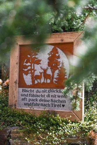 a sign with a picture of trees on it at Ferienhaus Schneiderhäusl Zillertal in Stummerberg