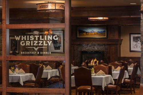 a dining room with tables and a fireplace at Wyoming Inn of Jackson Hole in Jackson